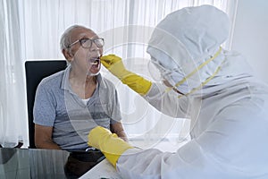 Elderly man doing swab test with medical worker