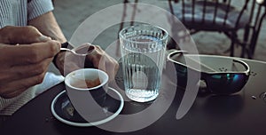 Elderly man drinking espresso coffee at an outdoor cafe