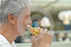 Elderly man eating fast food