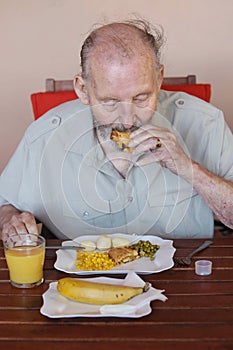 Elderly man eating healthy lunch in care home