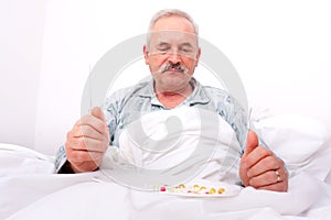 Elderly man eating meds