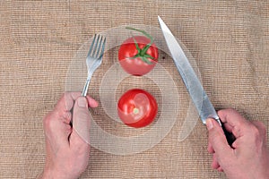 Elderly man eating tomatoes with a knife and fork