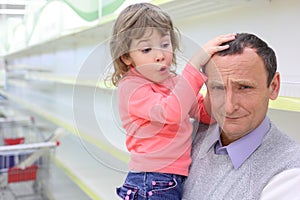 Elderly man at empty shelves in shop with child