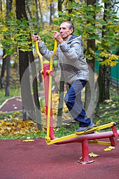 Elderly man is engaged on sport simulator in photo