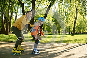 Elderly man enjoying sports in sunny summer park with his little son