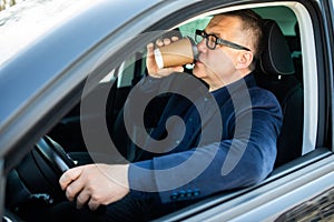 Elderly man experience self-driving smart car and has a cup of coffee