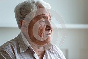 Elderly man feels sad and lonely looking away closeup face