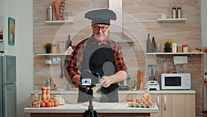 Elderly man filming cooking vlog