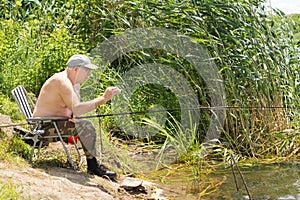 Elderly man fishing carefully testing his line