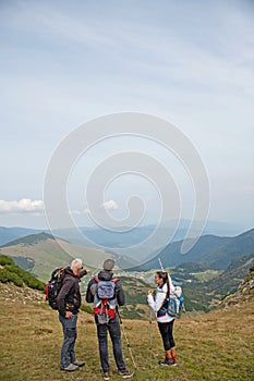 An elderly man giving a tour for a young group of people