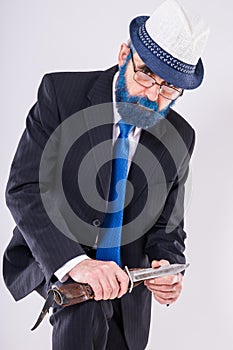 An elderly man in glasses with blue beard holds a huge knife in his hands and looks frighteningly from under his foreheads photo