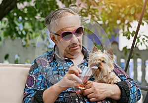 An elderly man with glasses and a dog