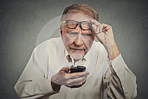 Starší muž brýle s problémy vidění mobilní telefon 
