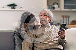 Elderly man with granddaughter using tablet together