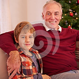 Elderly man, grandson and christmas portrait on sofa with love, bonding or happiness in family home. Boy, grandfather