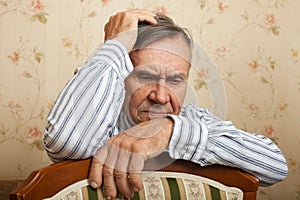 Elderly man grieves at home.
