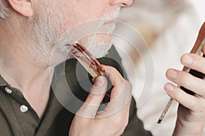 Elderly man grooming beard with a comb photo