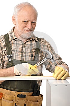 Elderly man hammering