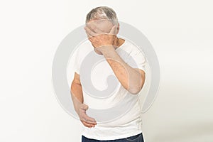 Elderly man with hand on his temple has a headache