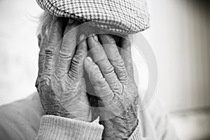 Elderly man with hands on face