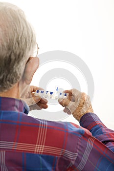 Elderly man holding seven-day pill box. photo