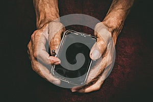 Elderly man holds in his hands an empty wallet.