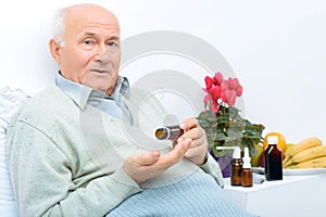 Elderly man holds his medicine vial