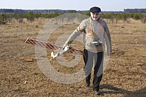 Elderly man holds RC airplane with a broken propeller