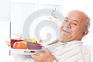 Elderly man in a hospital bed eating