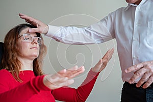 An elderly man hypnotizes a female patient. A woman in a session with a male hypnotherapist during a session. Therapist