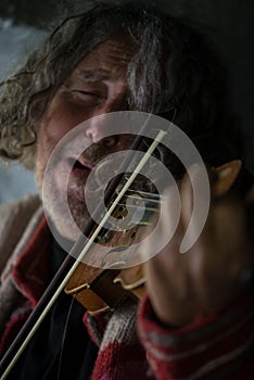 Elderly man immersed in his music playing a violin