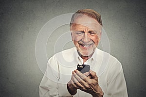 Elderly man looking at his smart phone while text messaging