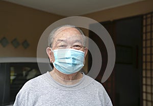 Elderly man with medical face mask at home