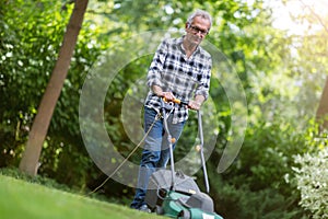 Elderly man mowing the lawn