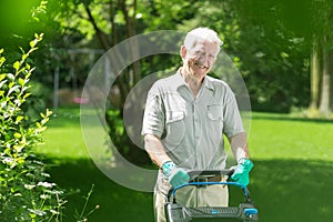 Elderly man mowing the lawn