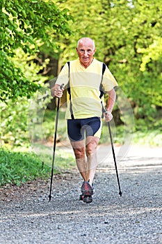 Elderly man with Nordic walking photo