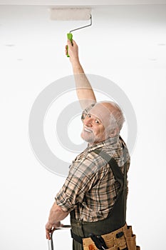 Elderly man painting the ceiling