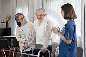 an elderly man patient being assist by home health nurse,using walker to walk at home