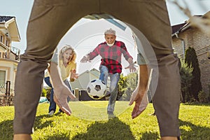 Elderly man performing a free kick while playing football in the backyard