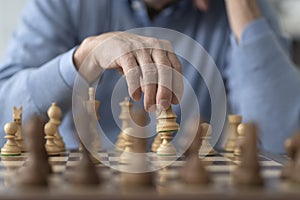 Elderly man playing chess at home