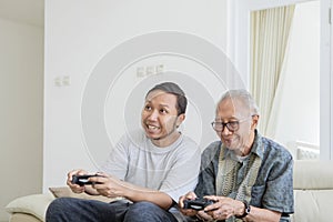 Elderly man playing video games with his son