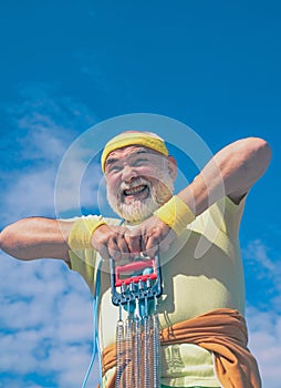 Elderly man practicing sports on blue sky background. Grandfather pensioner. Sporting. Senior sportsman in sport center