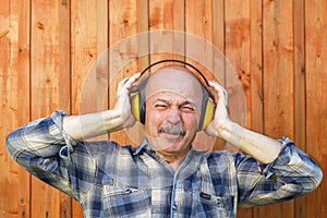 Elderly man in a protective building headphones.