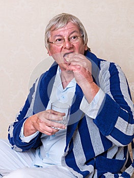 Elderly man putting dentures in