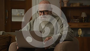 Elderly Man Putting On Glasses, grandfather work on laptop