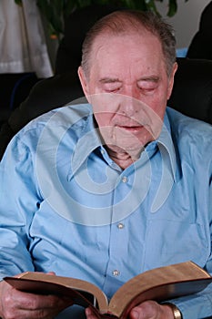 Elderly man reading Bible