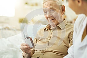 Elderly man reading instructions on medication at home