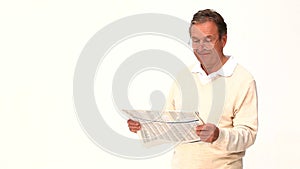 An elderly man reading newspaper with glasses