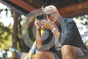 Elderly man`s hobby is photography. Retirement travel, outdoor activities. Adventures in life of senior people