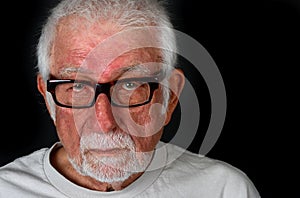 Elderly man with sad expression shedding a tear